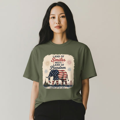 THAILISH.SHOP olive green 100% cotton unisex tee with an elephant draped in the US flag, fireworks, and city skyline.